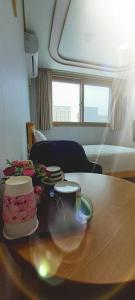 a table with a cake and two cups on it at Haha pension in Boryeong