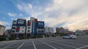 a parking lot with a car parked in front of a building at Haha pension in Boryeong