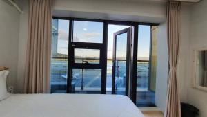 a bedroom with a bed and a large glass window at Haha pension in Boryeong +13 photos