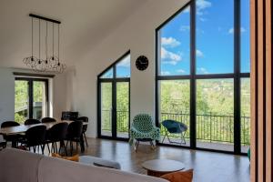 a living room with a table and chairs and large windows at Bran Villa - A-frame Orchard Hygge in Bran
