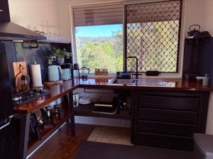 a kitchen with a counter with a sink and a window at Hayden's Place in Wamuran