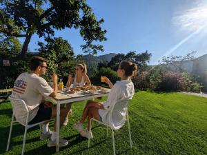 a group of people sitting at a table in the grass at Cave Canvas in Mount Ābu