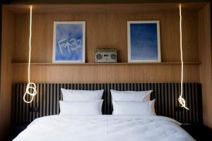 a bedroom with a bed with white sheets and a radio at ALPAMI Boutique Glockenbach in Munich