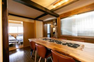 a dining room with a wooden table and chairs at コテージくつろぎ in Tsuru  +117 photos