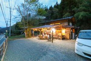 a car parked in front of a building with tables at コテージくつろぎ in Tsuru 