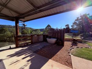 a patio with a fence and a tub in a yard at Hayden's Place in Wamuran