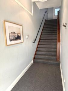 a hallway with a staircase with a picture on the wall at Royal Hotel Tumut in Tumut