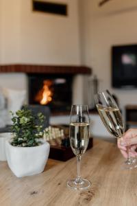 two glasses of white wine sitting on a wooden table at Mountain Chalet Donovaly with Sauna & Jacuzzi in Donovaly