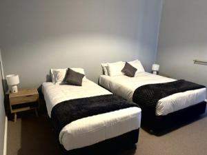 two beds in a hotel room withskirts at Royal Hotel Tumut in Tumut
