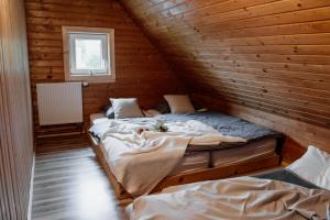 a room with two beds in a wooden cabin at Mountain Chalet Donovaly with Sauna & Jacuzzi in Donovaly