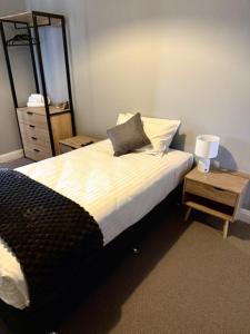 a bedroom with a bed with a mirror and a night stand at Royal Hotel Tumut in Tumut