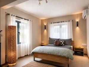 a bedroom with a bed and two windows at Villa Ptit Bouchon - En face de la Plage - Facing beach with Ocean views in Bouchon +37 photos