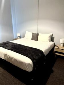 a bedroom with a large bed with white sheets and pillows at Royal Hotel Tumut in Tumut