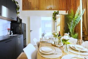 a dining room table with white plates and flowers on it at Cofy Rentals - old town, quiet area, air-conditioning, free parking, 24-7 express check-in-out, close to green parks, everything you need for living in Pärnu