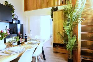 a dining room with a table with white plates and a plant at Cofy Rentals - old town, quiet area, air-conditioning, free parking, 24-7 express check-in-out, close to green parks, everything you need for living in Pärnu