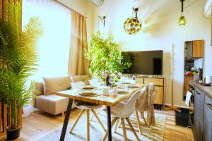 a living room with a table and a couch at Cofy Rentals - old town, quiet area, air-conditioning, free parking, 24-7 express check-in-out, close to green parks, everything you need for living in Pärnu +17 photos