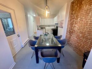 a dining room table with blue chairs and a brick wall at Full Kitchen METRO DE LEGLISE Room B in Montreal +9 photos