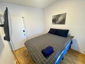 a small bedroom with a bed and a television at Full Kitchen METRO DE LEGLISE Room B in Montreal