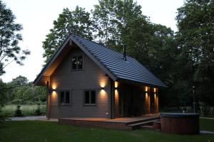 a small house with a gambrel roof with lights on it at Sikana Mõisa saun in Sikana