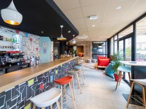 a bar in a restaurant with colorful stools at Ibis Toulouse Purpan Aeroport in Toulouse