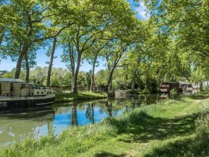 a canal in a park with trees and a boat at Ibis Toulouse Purpan Aeroport in Toulouse