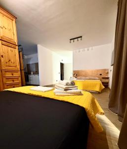 a bedroom with two beds and a yellow blanket at INCLUSIVeLOFT in Legnano