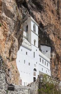 a large white building on the side of a mountain at House by the River in Orja Luka