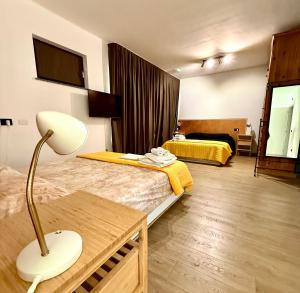 a hotel room with two beds and a lamp at INCLUSIVeLOFT in Legnano