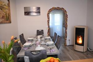 ein Esszimmer mit Tisch und Kamin in der Unterkunft Apartment Sofia in Barnbach