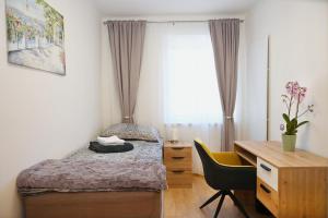ein kleines Schlafzimmer mit einem Bett und einem Schreibtisch in der Unterkunft Apartment Sofia in Barnbach
