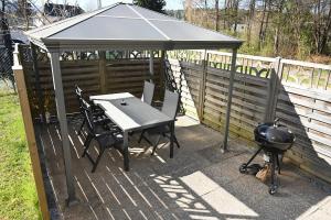 ein Pavillon mit Grill, Tisch und Stühlen in der Unterkunft Apartment Sofia in Barnbach