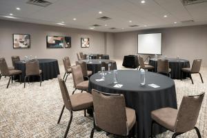a conference room with tables and chairs and a screen at SpringHill Suites Chicago Downtown/River North in Chicago