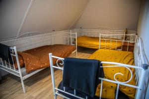 two bunk beds in a room with a chair at Vakantiehuis 'Oan de Feart' in De Valom