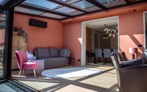 a living room with pink walls and a couch at Vakantiehuis 'Oan de Feart' in De Valom