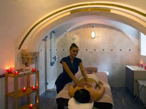 a woman is sitting on a bed with a man at Mercure Moulins Centre Hôtel de Paris in Moulins