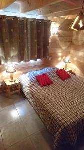 um quarto com uma cama com duas almofadas vermelhas em Le Solé Bassurois em Basse-sur-le-Rupt