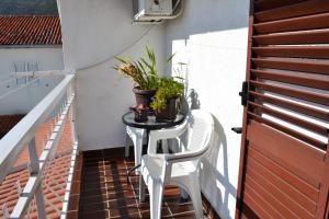 un pequeño balcón con una mesa con plantas. en Apartment Matea, en Petrovac na Moru