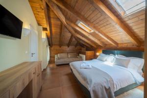 a bedroom with a large bed and a flat screen tv at Leon Suites Nemea in Neméa