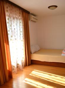 a bedroom with a bed and a window at Apartment Matea in Petrovac na Moru