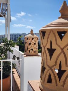 a balcony with two large vases on top of a building at Riad Vejerísimo - Unique private patio house 8 pers in Vejer de la Frontera +47 photos