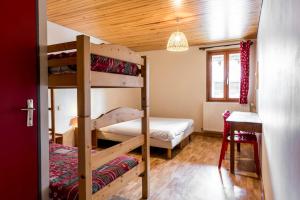 a bedroom with two bunk beds and a table at Le Charmagit in La Roche-sur-Foron