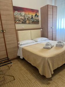 a bedroom with a bed with two towels on it at Campus Baia Serena in Bellaria-Igea Marina