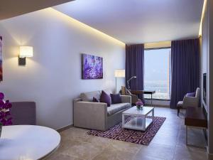 ein Wohnzimmer mit Sofa und Tisch in der Unterkunft Mercure Dubai Barsha Heights Hotel Suites And Apartments in Dubai