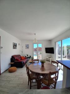 a living room with a table and a couch at Maison avec piscine in Cessenon