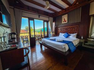 a bedroom with a bed with blue pillows on it at NamKhan Riverside in Luang Prabang +89 photos