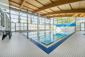a large swimming pool in a building with a large window at Jubilee Two Bedroom House Pet Friendly in Penrith