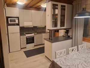 a kitchen with white cabinets and a bed in a room at Aabro, Levi in Kittilä