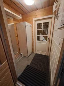 a small room with a refrigerator and a door at Aabro, Levi in Kittilä +6 photos