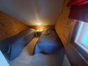 two beds in a small room with a window at Aabro, Levi in Kittilä