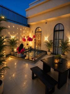 a woman sitting on the floor in a room with lights at The Benjamins Pool Villa in Jodhpur